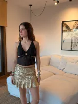 Top negro con estampado de lunares blancos, escote en V, breteles finos, argolla en el busto y cut-outs debajo del busto.