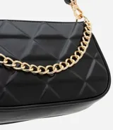 Bolso baguette pequeño color crema, confeccionado en cuero sintético con textura matelaseada en forma de rombos. Presenta correa corta al hombro y detalle de cadena dorada en el frente.