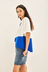 Remera blanca con recorte inferior azul y estampado frontal con la palabra 'AMOUR' en azul.