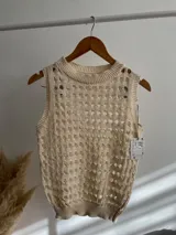 Chaleco tejido de algodón color crema con diseño calado.