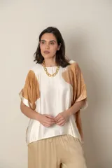 Blusa italiana color natural con estampado de hojas grandes en tonos marrones. Tiene cuello redondo y mangas cortas amplias.