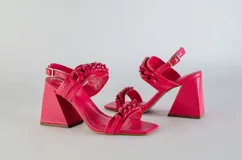 Sandalias de tacón fucsia con puntera cuadrada, tiras gruesas con diseño de cadena y pulsera con hebilla.