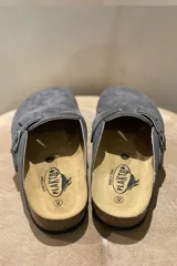 Zuecos grises marca Plakton, confeccionados en cuero vacuno, con hebilla lateral ajustable, plantilla anatómica con memory cushion y suela de goma y corcho.