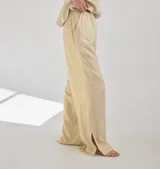 Pantalón de lino color ladrillo, de corte recto con tajos laterales en el ruedo y cintura elastizada.