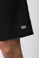 Short de baño azul marino con cordón blanco en la cintura y logo de la marca en la pierna derecha.