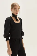 Top negro de calce al cuerpo con escote cuadrado amplio. Mangas largas abullonadas con puños elastizados.