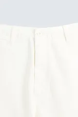 Pantalón de vestir color blanco hueso, de corte relajado (relaxed fit) y tejido de algodón con textura espiga. Presenta bolsillos frontales, bolsillo cerillero y bolsillos traseros de vivo.