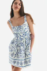 Vestido corto de algodón con estampado de motivos marinos en azul, con costuras estilo corset adelante y atrás. Modelo de cuerpo entallado con breteles anchos, escote cuadrado y cierre oculto con corchete en la espalda. Costura fruncida en la cintura y pollera con vuelo. Cuerpo forrado.