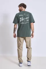 Remera de manga corta color marrón oscuro con cuello redondo y un pequeño texto bordado en blanco en el pecho.