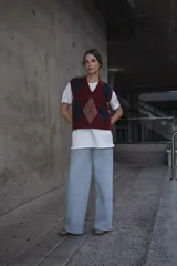 Chaleco tejido con patrón de rombos en bordeaux, azul y marrón. Con cuello en V y sin mangas.