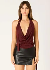 Top halter color vino con escote drapeado, bretel con argolla metálica y lazo lateral.