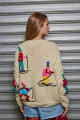 Sweater tejido color crema con diseño de esquiadores en colores.