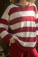 Sweater tejido artesanalmente con hilado 70% algodón y 30% acrílico, a rayas horizontales rojas y blancas, con cuello redondo y mangas largas.