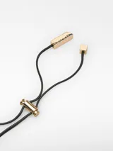 Collar con cordón largo regulable, pieza de resina color ámbar y perla móvil blanca.