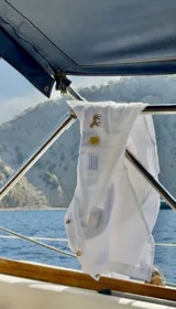Camisa blanca de lino con bordados de caballito, sol y la bandera de Uruguay.