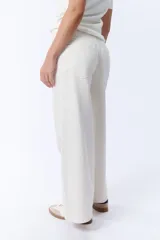 Pantalón de jean de tiro alto, color crudo, con corte palazzo y pierna ancha.