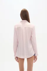 Camisa de viscosa color crema con finas rayas verticales negras, corte al cuerpo, cuello camisa y dos bolsillos frontales con tapa. Posee botones frontales y mangas largas con puño.