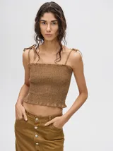 Top corto negro con textura fruncida, tirantes finos con lazos ajustables y corte crop.