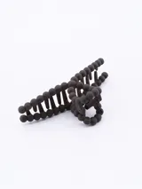 Pinza para el pelo color marrón oscuro, con forma de mandíbula y decorada con cuentas redondas.