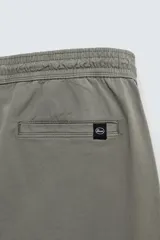 Pantalón jogger negro de corte slim fit, confeccionado en tejido de algodón con cintura elástica ajustable con cordón, bolsillos frontales y traseros de vivo, y bajo con puño elástico.