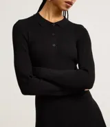 Vestido corto negro de punto con cuello polo, manga larga y botones en el escote.
