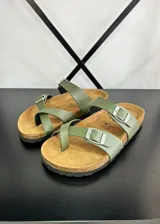 Sandalias planas color verde militar, con dos tiras anchas ajustables con hebilla metálica plateada y plantilla de corcho.