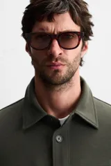 Sobrecamisa color beige de corte relaxed fit, con cuello solapa, manga larga con puños abotonados, bolsillos de plastrón con solapa en el pecho y bolsillos de vivo en la cadera. Cierre frontal con botones.