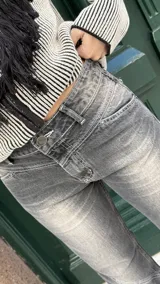 Pantalón de jean gris oscuro, de corte recto y tiro medio, con costuras decorativas en contraste.