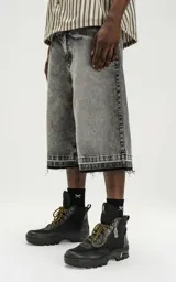 Bermuda denim larga color gris con efecto lavado, calce oversize, cintura con cinturón de ajuste y ruedo desflecado.