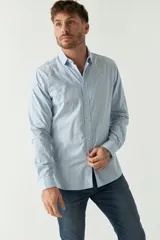 Camisa de hombre a rayas verticales celestes y blancas, corte slim fit, manga larga, logo bordado en el pecho y cartera con botones.
