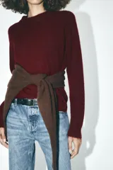 Sweater de punto color borgoña, de corte recto, cuello redondo y manga larga.