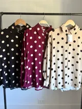 Camisa de manga larga en fibrana color bordó con estampado de lunares grandes en color crema. Presenta cuello camisero y cierre frontal de botones.