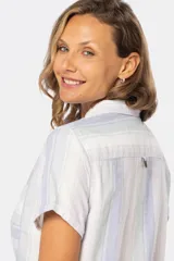 Camisa de lino a rayas de colores pastel con medio botón. Tiene dos bolsillos en el pecho, botones metálicos personalizados y dobladillo en la manga.