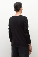 Remera de manga larga color blanco con escote a la base y corte recto.