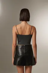 Musculosa gris de bretel fino, con lurex y cuello cuadrado.