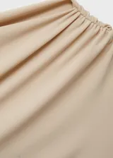 Vestido corto color beige con escote asimétrico y frunces laterales.
