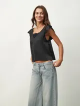 Blusa negra de satén con escote en V y detalle de encaje en el escote.