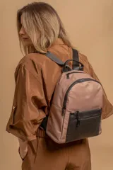 Mochila urbana color gris con detalles en cuero sintético negro. Cuenta con un compartimento principal amplio y un bolsillo frontal con cierre.