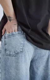 Pantalón de denim celeste con lavado gastado, corte wide leg y cinco bolsillos.