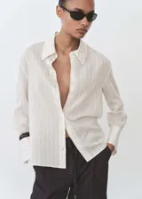 Camisa de manga larga con puños abotonados, diseño recto, cuello camisero y estampado a rayas verticales.