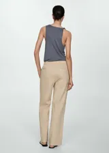 Pantalón color beige de tiro medio, corte recto y diseño largo. Cuenta con dos bolsillos delanteros, cierre de lazo y dos bolsillos de parche en la parte posterior.