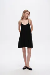Vestido corto negro de lino y algodón, con breteles finos y corte holgado.