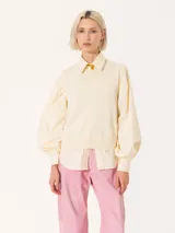 Sweater color crema de tejido de punto fino, con cuello redondo y mangas largas abullonadas.