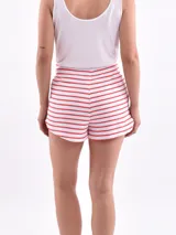 Short blanco con rayas horizontales rojas, cintura elastizada con cordón ajustable y bolsillos laterales.