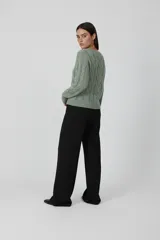 Sweater de poliéster color bordó, con diseño de ochos, corte holgado y cuello a la base.