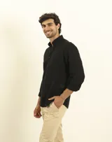 Camisa azul marino de lino y algodón, con cuello abotonado, manga larga con puños enrollados, bolsillo de parche en el pecho y cierre frontal con botones.