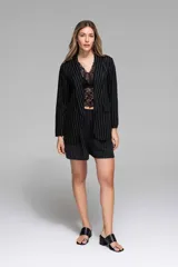 Short sastrero azul marino con finas rayas verticales blancas, de tiro alto y corte holgado. Incluye lazo del mismo tejido para ajustar en la cintura y bolsillos laterales.