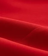Bermuda roja de crepé con cierre delantero, bolsillos laterales con botones y pliegues.