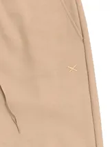 Pantalón de jogging color beige, de corte babucha, con cintura y tobillos elastizados y cordón ajustable.