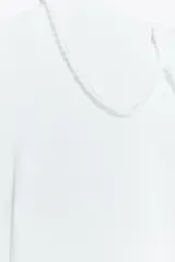 Camiseta blanca de manga corta con cuello bobo combinado a tono y acabados con fornituras a tono. Cierre en espalda con abertura y botón.